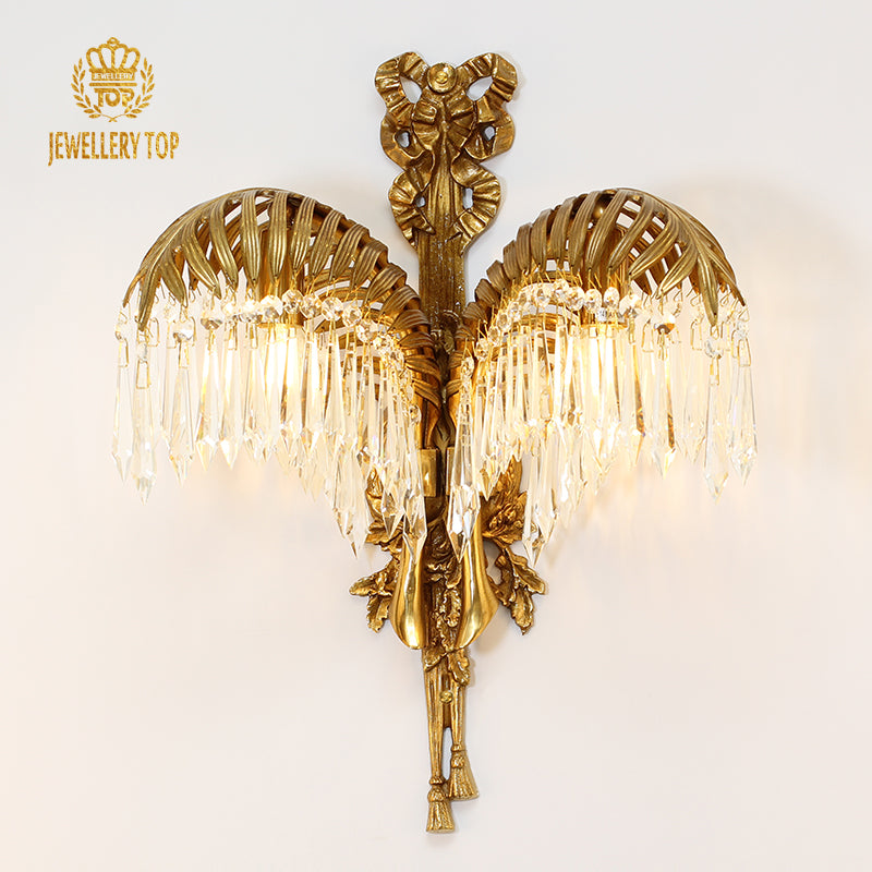 Detailed front view of the brass sconce highlighting the textured palm frond design and sparkling pendants.