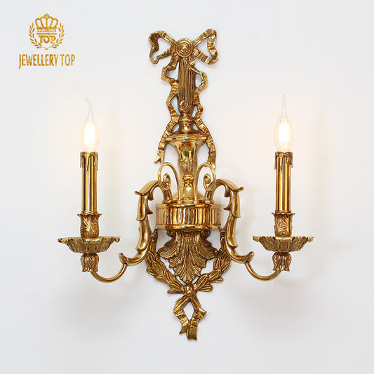 JEWELLERY TOP branded product shot of the ornate golden brass wall sconce on a white background.