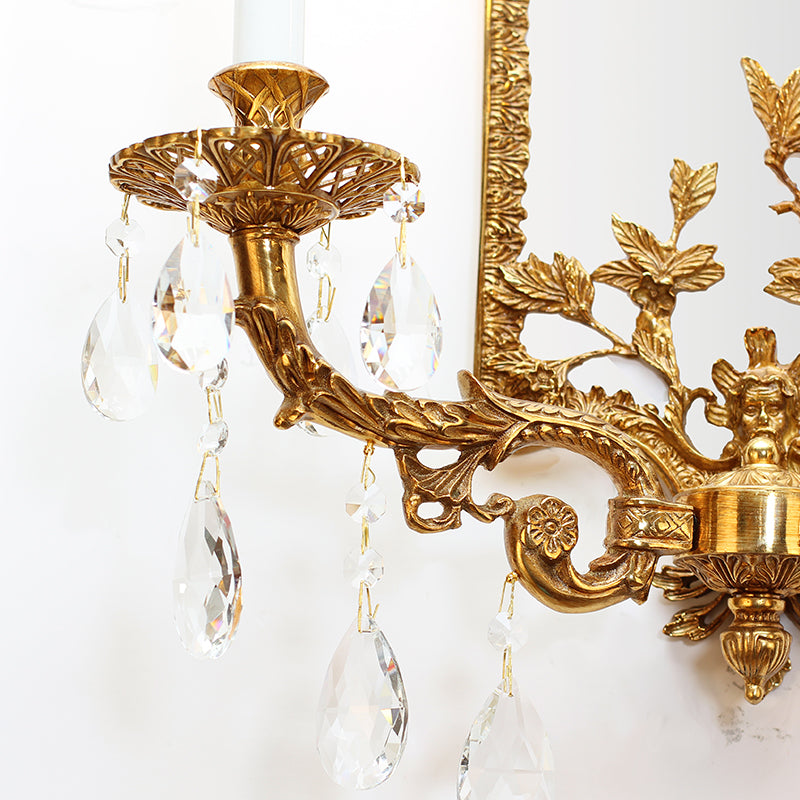 Close-up side view focusing on a single candle-style bulb and the hanging crystal droplet pendants of the wall light.