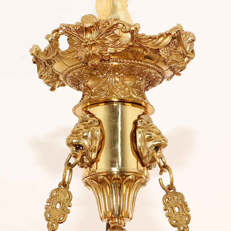 Macro close-up of the finely sculpted golden cherub figure holding a ring.