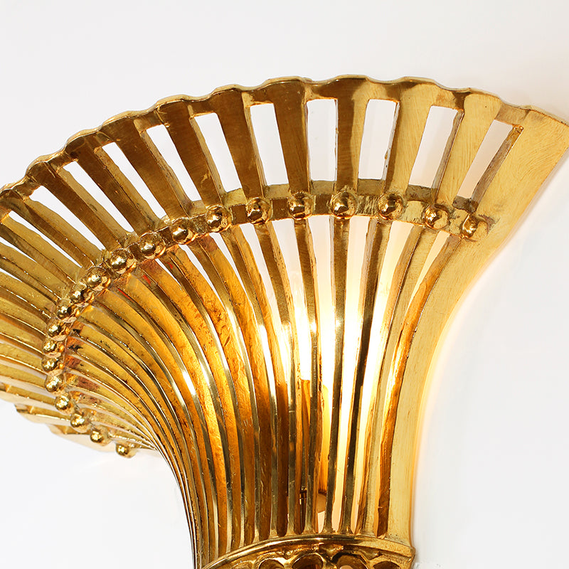 Extreme macro shot of the ornate openwork lattice and brass bow decoration on the lamp’s central column.