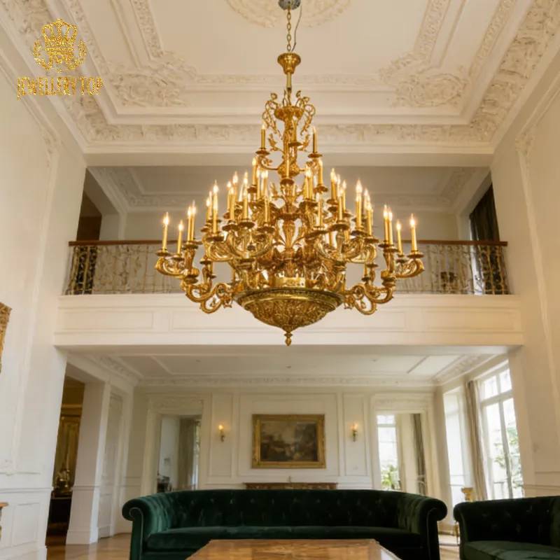Majestic large size decorative brass chandelier in a two-story room with green velvet sofa.