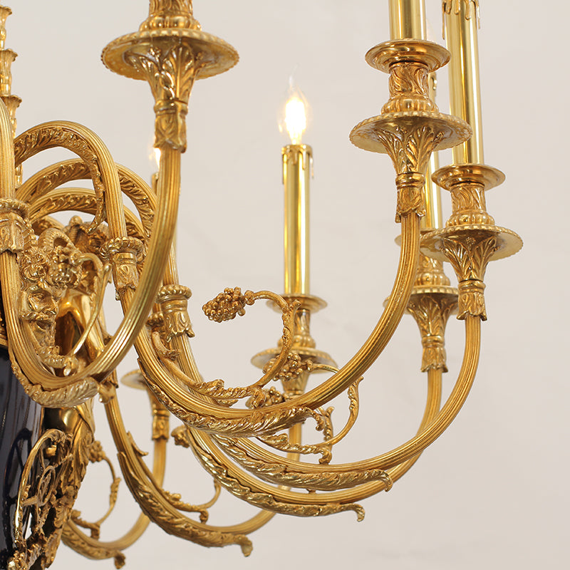 Detailed macro shot of ornate brass scrollwork and a lit candle bulb on the chandelier arm.