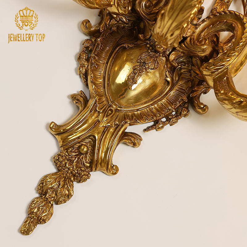 Close-up detail of the sconce’s ornate edge, showcasing complex scrollwork and classic European design elements.