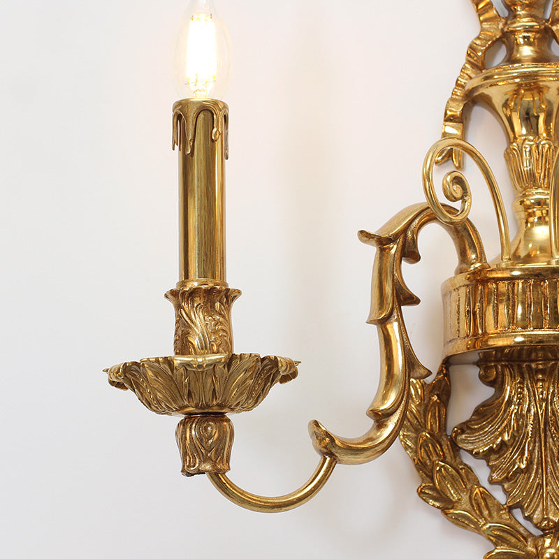 Side profile highlighting the curved arm, candle bulb, and exquisite metalwork of the sconce.