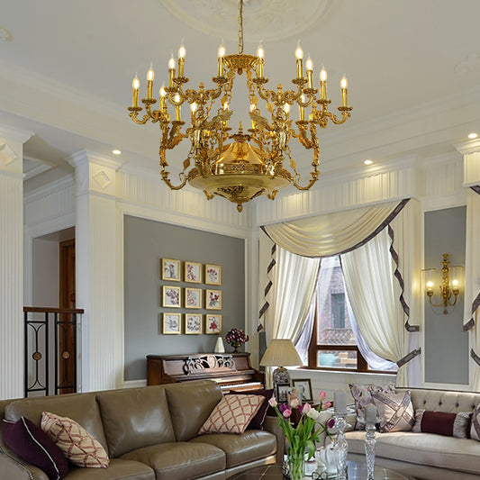 A luxury chandelier installed in an elegant grand foyer with a winding staircase and ornate wall moldings.
