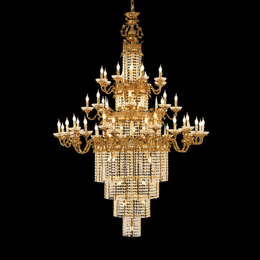 A grand golden brass chandelier with stepped crystal layers, isolated on black background.