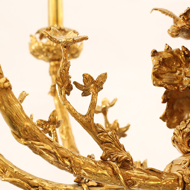 Extreme detail shot of textured brass branches and leaf carvings on the French-style chandelier.