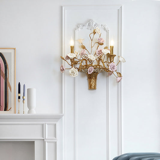 The brass and ceramic wall sconce installed on a white wall next to a fireplace and decorative artwork, showcasing its home decor appeal.