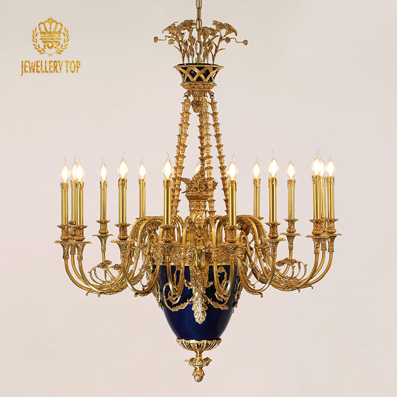 JEWELLERY TOP's brass chandelier with blue ceramic detail against a beige wall.