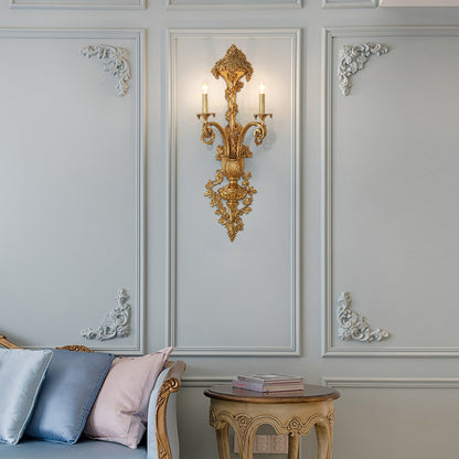 Lifestyle image of the antique bronze wall lamp installed in a classic living room with sofa and books.