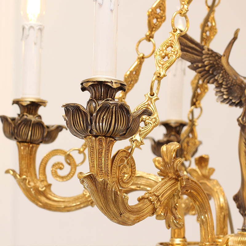 Extreme close-up of ornate brass lotus base, phoenix detail, and candle bulb on chandelier arm.