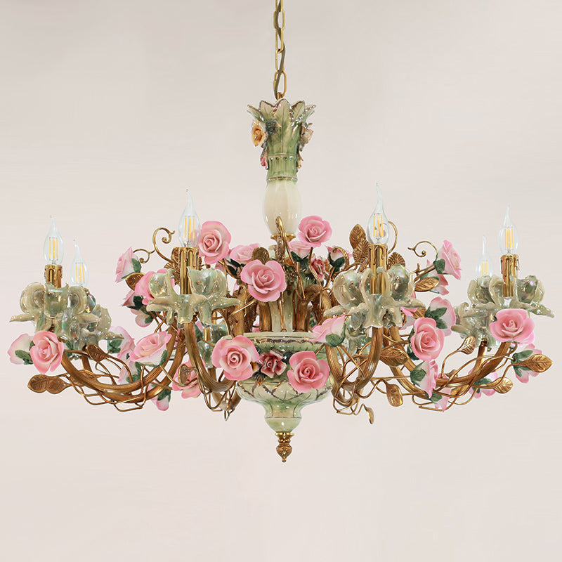 French-style brass chandelier with a pale green ceramic center column and pink flowers.