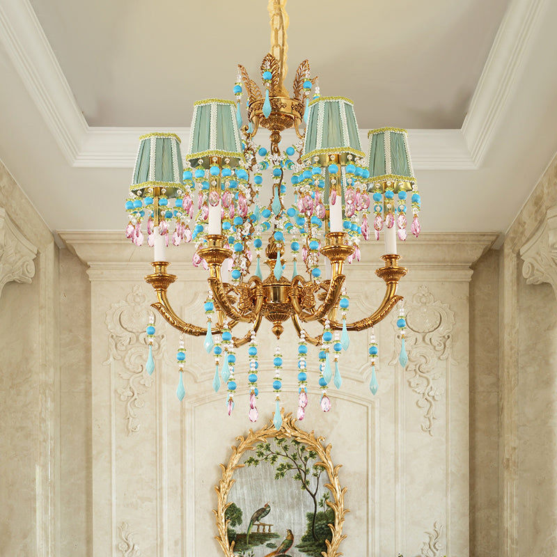 A French art decorative brass chandelier installed in a high-ceilinged room with a gilded mirror.