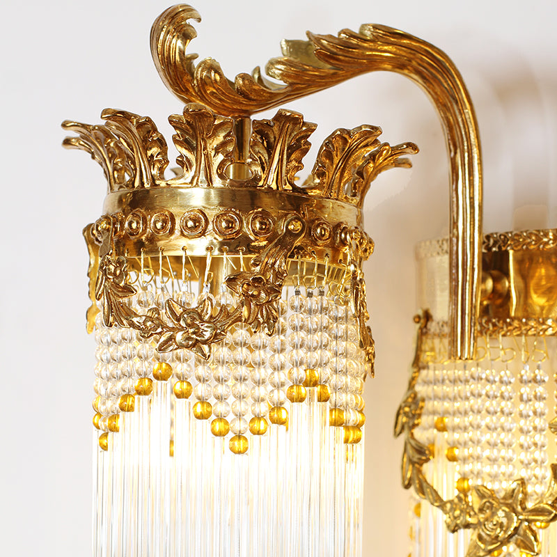 Macro shot focusing on the ornate brass floral and leaf carvings on the arm of the luxury wall lamp.