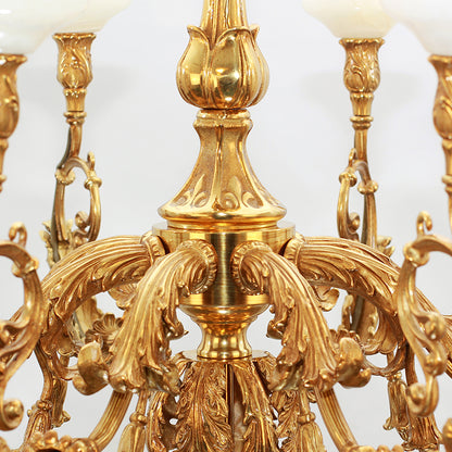 Detailed perspective of a brass chandelier's ornate central column, arms, and white lamp shades.