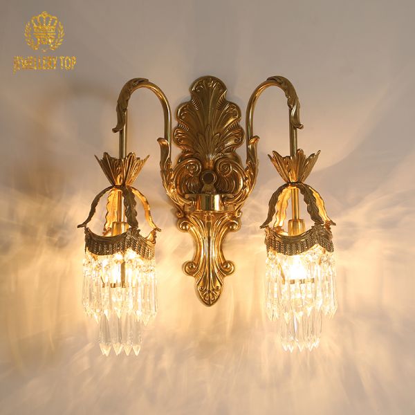 JEWELLERY TOP branded product shot of the ornate golden crystal wall lamp on a white background.
