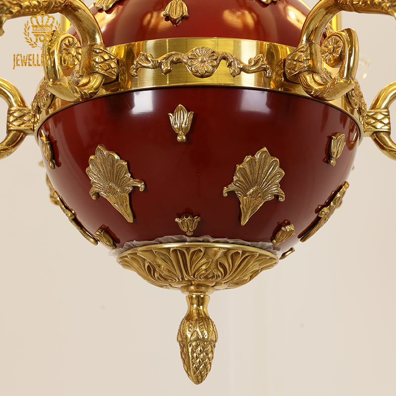 Extreme close-up of the deep red spherical center with gold scalloped and floral decorations.
