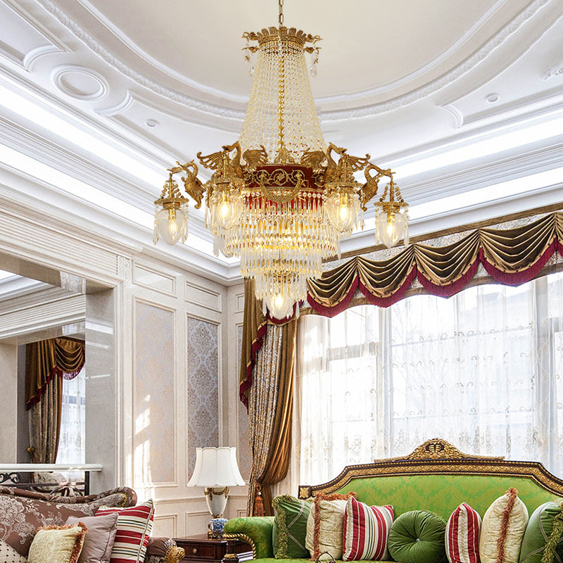 The large crystal brass chandelier installed in an elegant living room with green velvet sofa.