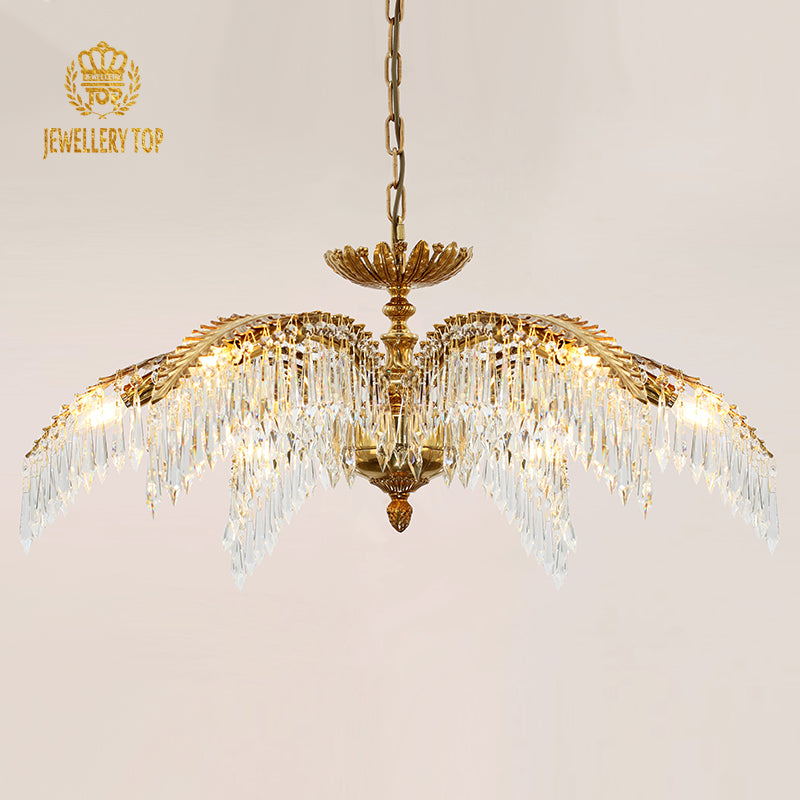 Close-up front view of the golden palm frond and crystal droplet details on the brass chandelier.