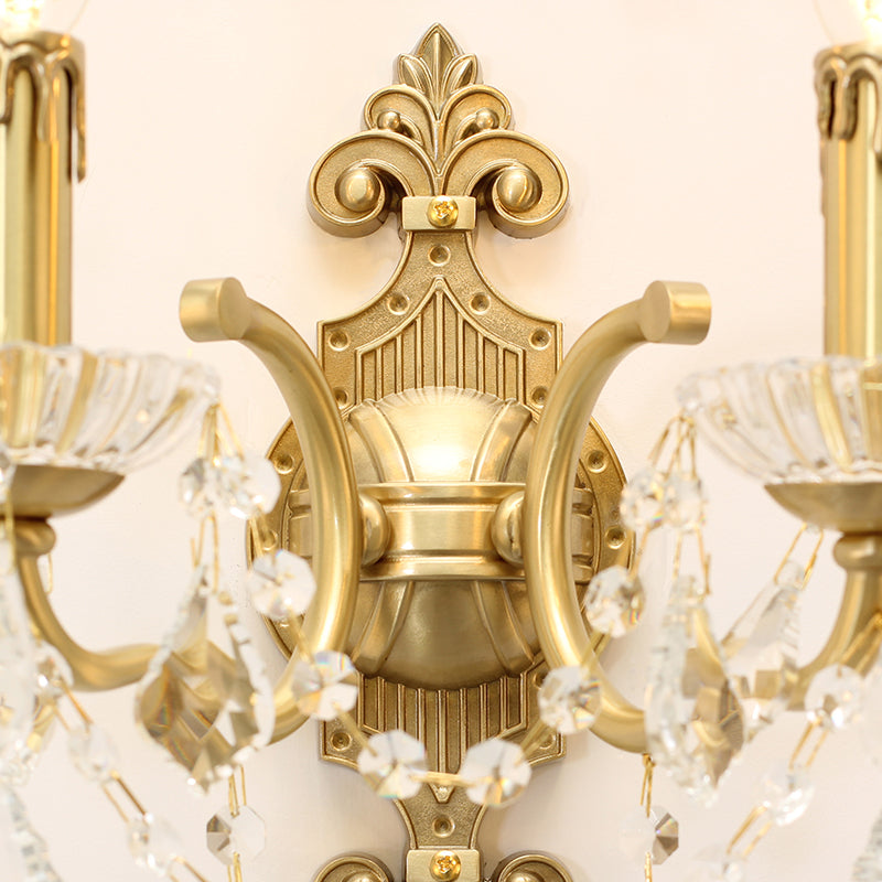 Extreme close-up macro detail of the sconce’s ornate central brass backplate with shell motif and scrollwork.