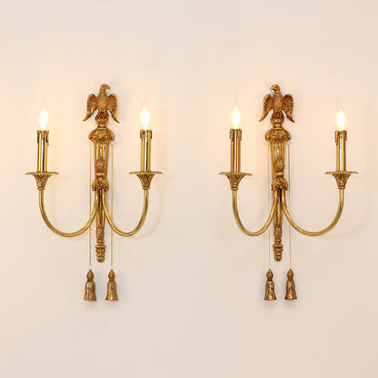Detailed view of the ornate brass chain and bead fringe suspended beneath the arm of the luxury wall light.