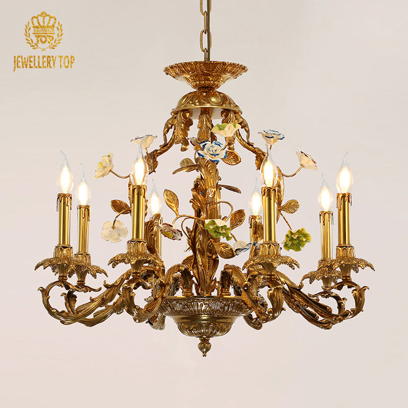JEWELLERY TOP brand's brass chandelier with ceramic decorations against a light background.