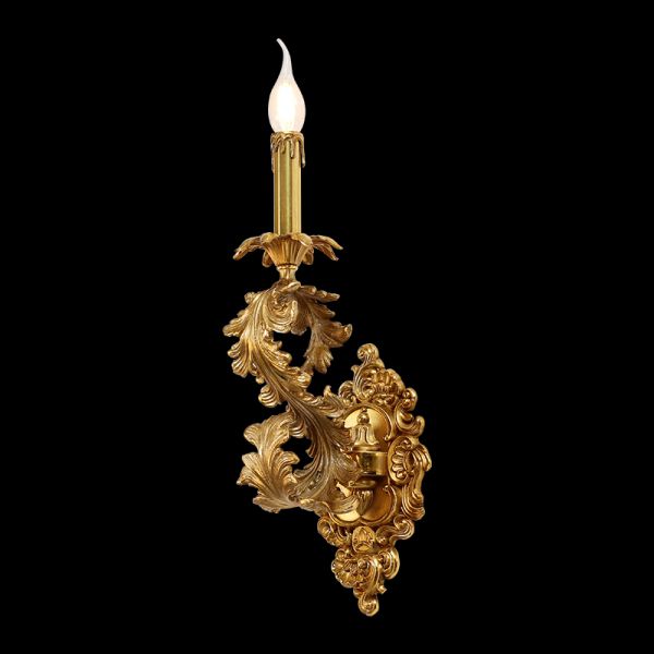 Flambeau de Rêve golden brass wall sconce with intricate Rococo scrollwork on a black background.