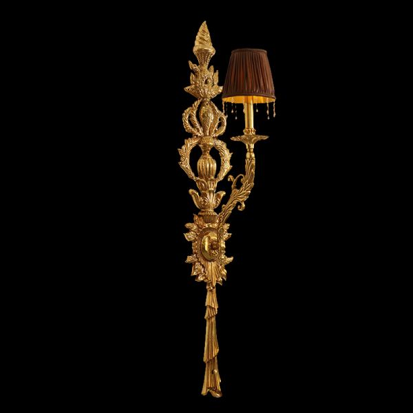 Extreme close-up of the baroque wall sconce’s spiral finial, textured leaves, and transparent candle bulbs.