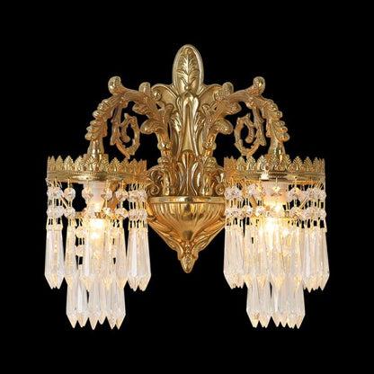 Front view of the golden Regal Crown brass wall sconce with crystal fringes, isolated on a black background.