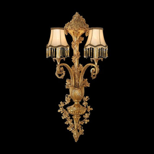 Front view of the ornate Vendange d’Or brass wall sconce with two fabric shades and grapevine carvings.