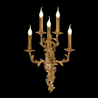 Front view of the five-light Symphonie Baroque brass wall sconce with intricate carvings, isolated on black.