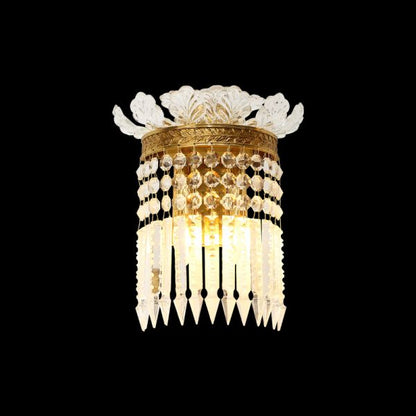 Gilded Crystal Cascade brass wall sconce with white porcelain flowers and crystal beads on a black background, JEWELLERY TOP.