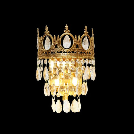 The full Couronne de Lumière brass wall sconce with a golden crown top and cascading crystal droplets on a dark background.