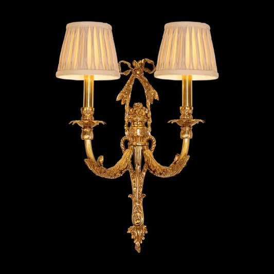 Front view of the Rococo Bow & Bough brass wall sconce with a central bow and two fabric shades on a dark background.