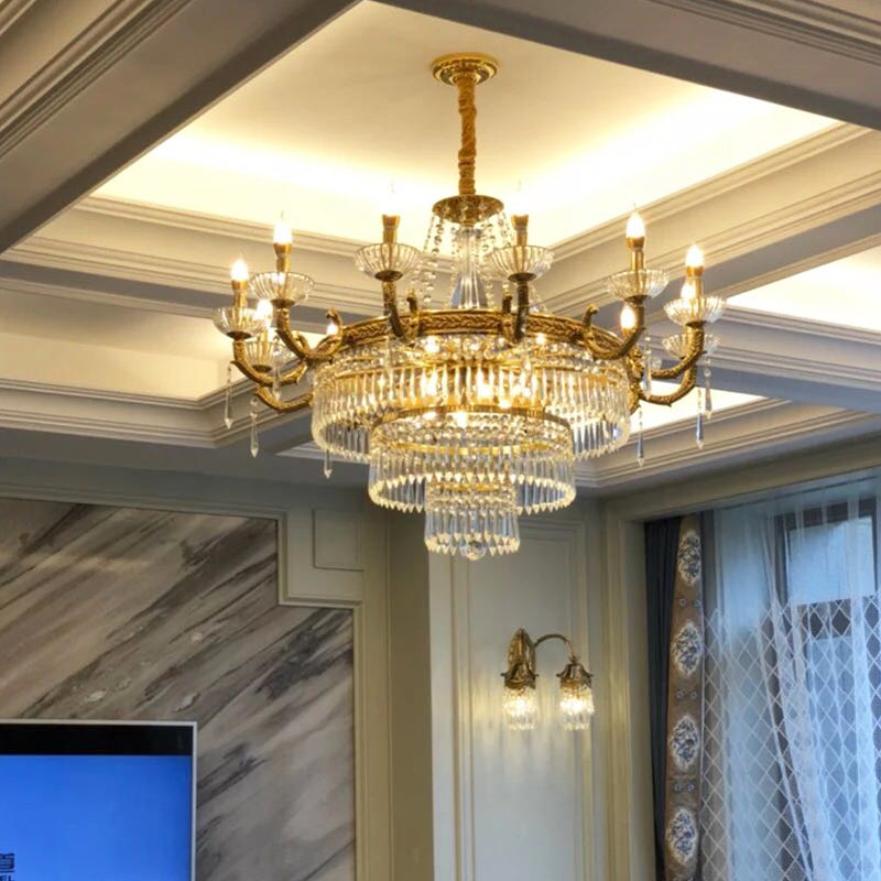 The brass crystal chandelier installed in a room with coffered ceiling, marble wall, and curtains.