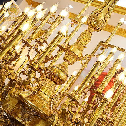 Close-up detail of exquisite Rococo-style scrolls and shell carvings on a brass chandelier frame.