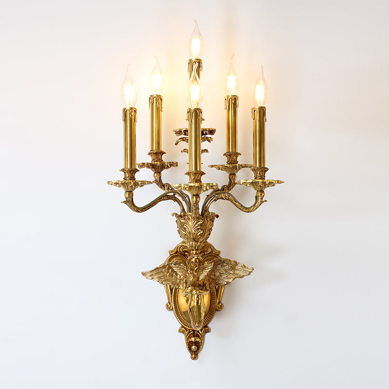 Side view of the ornate brass banquet wall lamp with angel and siren figures, mounted on a white wall.