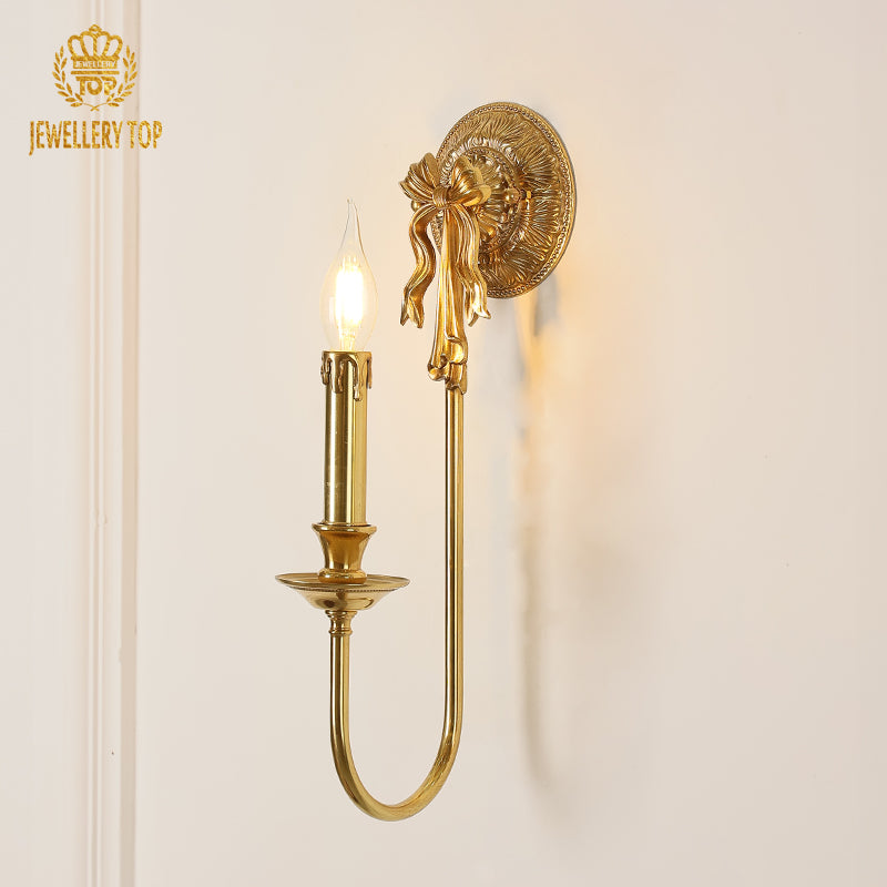 Front product view of the JEWELLERY TOP branded wall sconce with a candle bulb and ornate backplate.