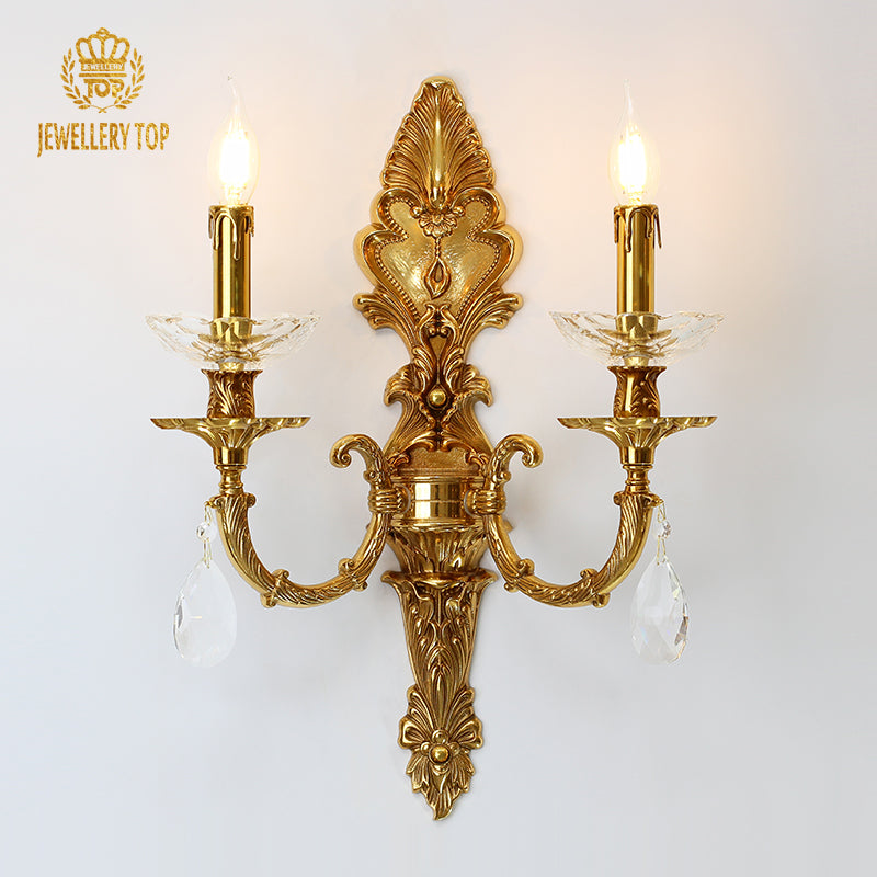 Versailles Lace & Crystal brass wall sconce with two candle bulbs and crystal drops on a white wall, JEWELLERY TOP.