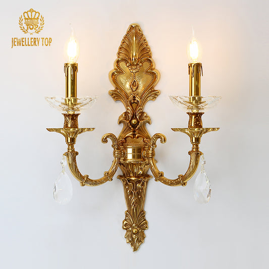 Versailles Lace & Crystal brass wall sconce with two candle bulbs and crystal drops on a white wall, JEWELLERY TOP.