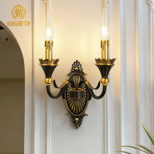 The French brass wall lamp with a dark central medallion and golden arms, installed beside an arched doorway.