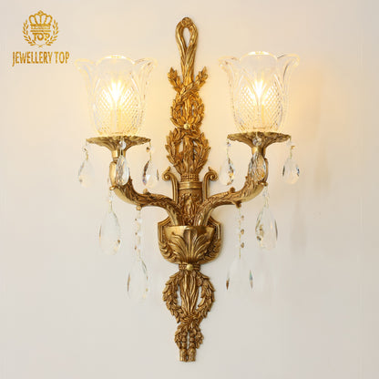 Front product view of the JEWELLERY TOP branded decorative wall sconce with two flower-shaped glass lampshades and lit bulbs.