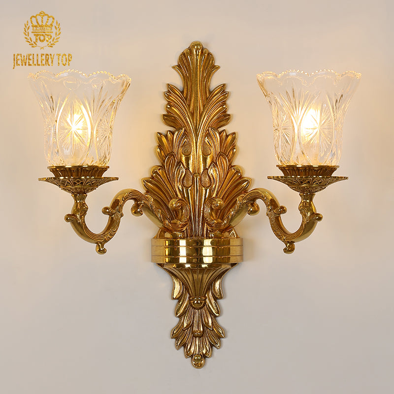 Front view of the JEWELLERY TOP Belle Époque golden brass double sconce with fluted glass shades on a white wall.