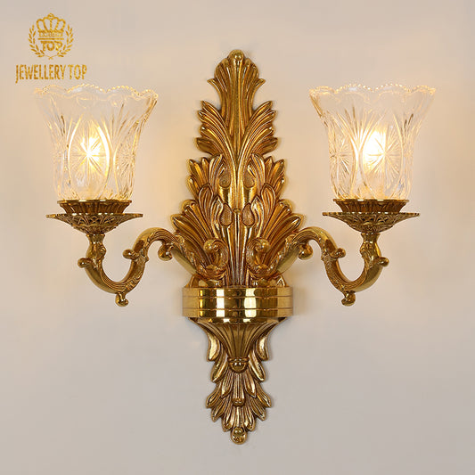Front view of the JEWELLERY TOP Belle Époque golden brass double sconce with fluted glass shades on a white wall.