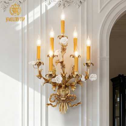 The decorative brass wall light installed on a light wall between two colorful stained-glass windows.