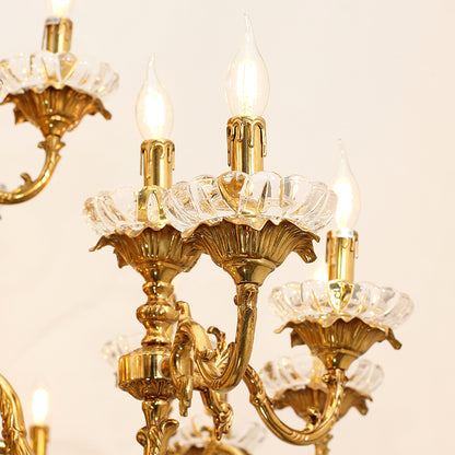 Macro close-up of a brass arm, candle bulb, and intricate floral crystal base on the chandelier.