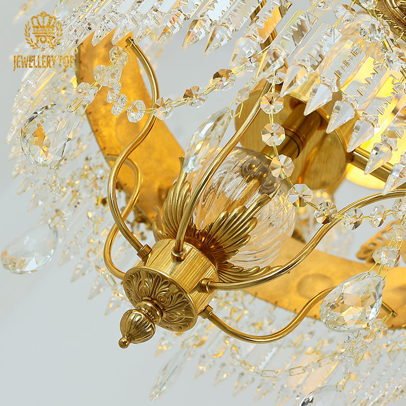 Macro close-up of the finely detailed golden foliate accents and the pleated linen shade trim.