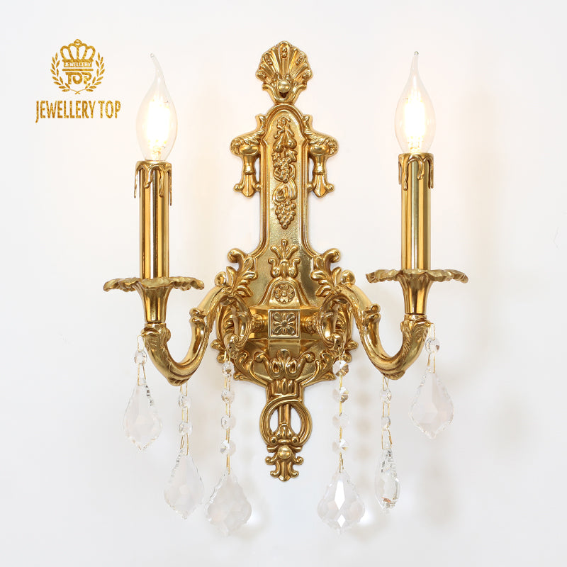 JEWELLERY TOP branded vintage brass sconce with intricate carvings, isolated on white.
