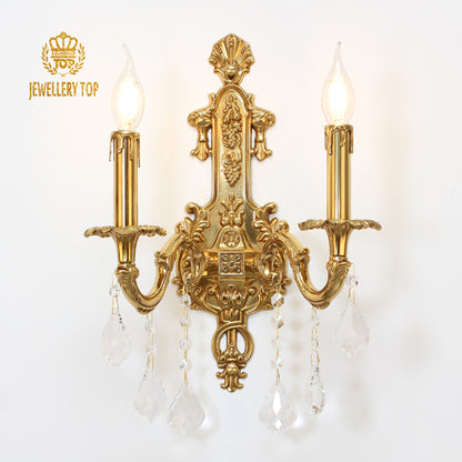 JEWELLERY TOP branded vintage brass sconce with intricate carvings, isolated on white.